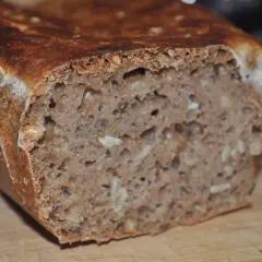 Chleb na zakwasie, z widocznymi ziarnami, kusi apetycznym wyglądem. Czy chleb na zakwasie powoduje wzdęcia? Zależy od indywidualnej tolerancji.