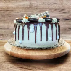 Wyśmienity tort z czekoladowym drip, ozdobiony ciasteczkami Oreo i kremowymi rozetkami. Idealny na każdą okazję!