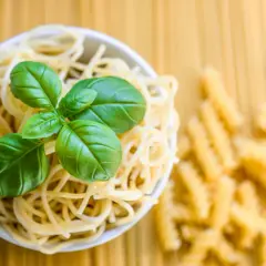 Miseczka spaghetti z bazylią, obok rozsypane fusilli. To klasyczne danie, gdzie co to jest semolina z pszenicy durum, stanowi podstawę.