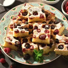 Szybkie ciasto na maślance z malinami i jeżynami, posypane cukrem pudrem. Idealne na deser.