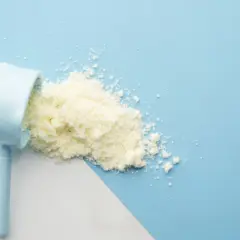 Łyżka z mlekiem w proszku, zastanawiasz się, szklanka mleka w proszku ile to gram?