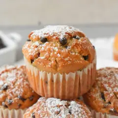 Pyszne muffinki z kawałkami czekolady, posypane cukrem pudrem, kuszą swoim wyglądem. Idealne na deser!