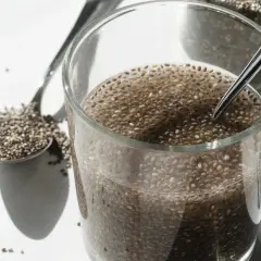 Nasiona chia pęczniejące w wodzie, łyżka pełna nasion. Prosty sposób, jak przygotować nasiona chia.