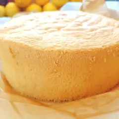 Puszysty, złocisty biszkopt na tort, upieczony na papierze do pieczenia.