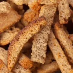 Zbliżenie na chrupiące grzanki z ciemnego pieczywa.