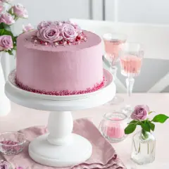 Elegancki tort urodzinowy dla kobiety, udekorowany różami i posypką. Idealny na wyjątkową okazję.