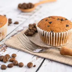 Dwa muffinki z kawałkami czekolady, ziarna kawy i widelec. Idealne na śniadanie, gdy zastanawiasz się, jak długo piec muffinki.