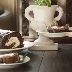 Pyszna rolada biszkoptowa czekoladowa z kremowym nadzieniem, podana na talerzyku.