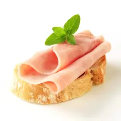 Kanapka z szynką i masłem, ozdobiona listkiem mięty. Zastanawiasz się, ile kalorii ma kanapka z szynką i masłem?