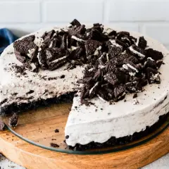 Pyszny sernik oreo na zimno, udekorowany pokruszonymi ciastkami. Idealny deser na gorące dni.