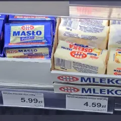 Na półce sklepowej widać opakowania masła. Jedno z nich, "Masło Polskie 82%", waży 100 gramów. Obok leżą mniejsze kostki masła "Osełka Mini" również po 100 gramów.
