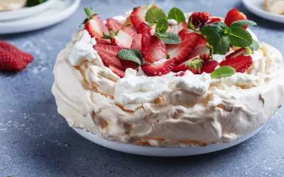 Pyszny tort bezowy z truskawkami i bitą śmietaną. Idealny przepis na letnie popołudnie.