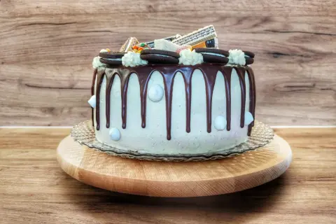 Wyśmienity tort z czekoladowym drip, ozdobiony ciasteczkami Oreo i kremowymi rozetkami. Idealny na każdą okazję!
