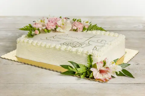 Eleganckie torty na komunie ozdobione kwiatami i symbolem hostii.