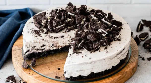 Pyszny sernik oreo na zimno, udekorowany pokruszonymi ciastkami. Idealny deser na gorące dni.