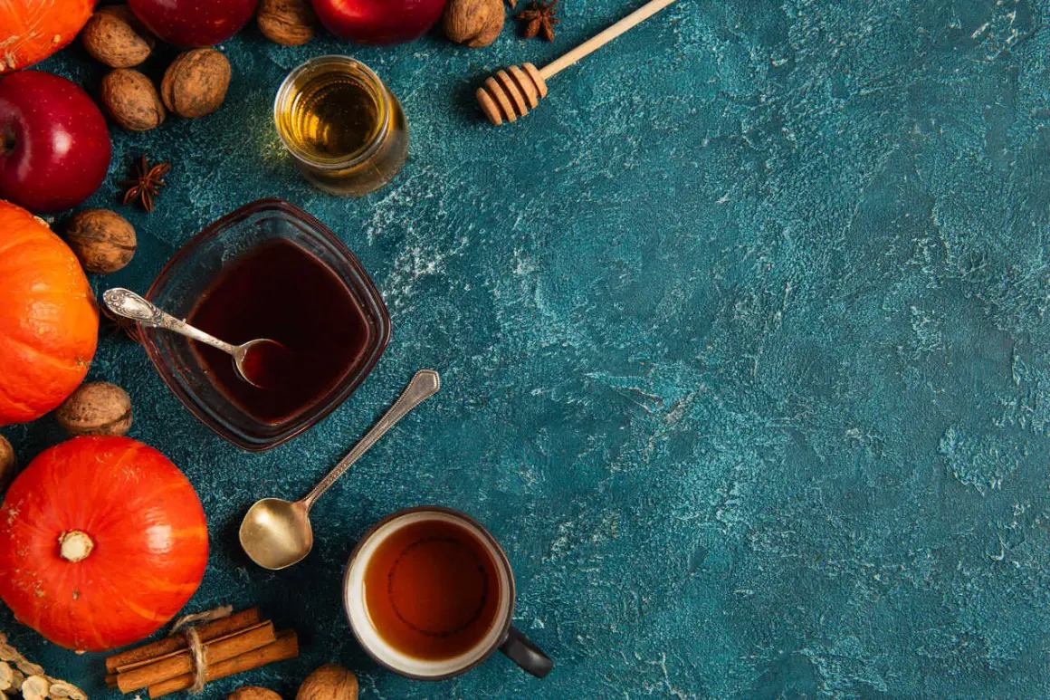 Jesienne składniki: dynie, jabłka, orzechy, cynamon i syrop pumpkin spice w miseczce.