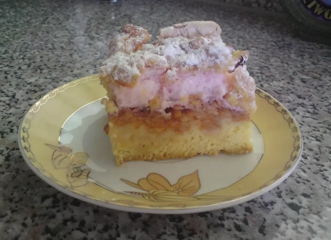 Pyszny placek z jabłkami i różowym kisielem, posypany cukrem pudrem. Idealny na deser.