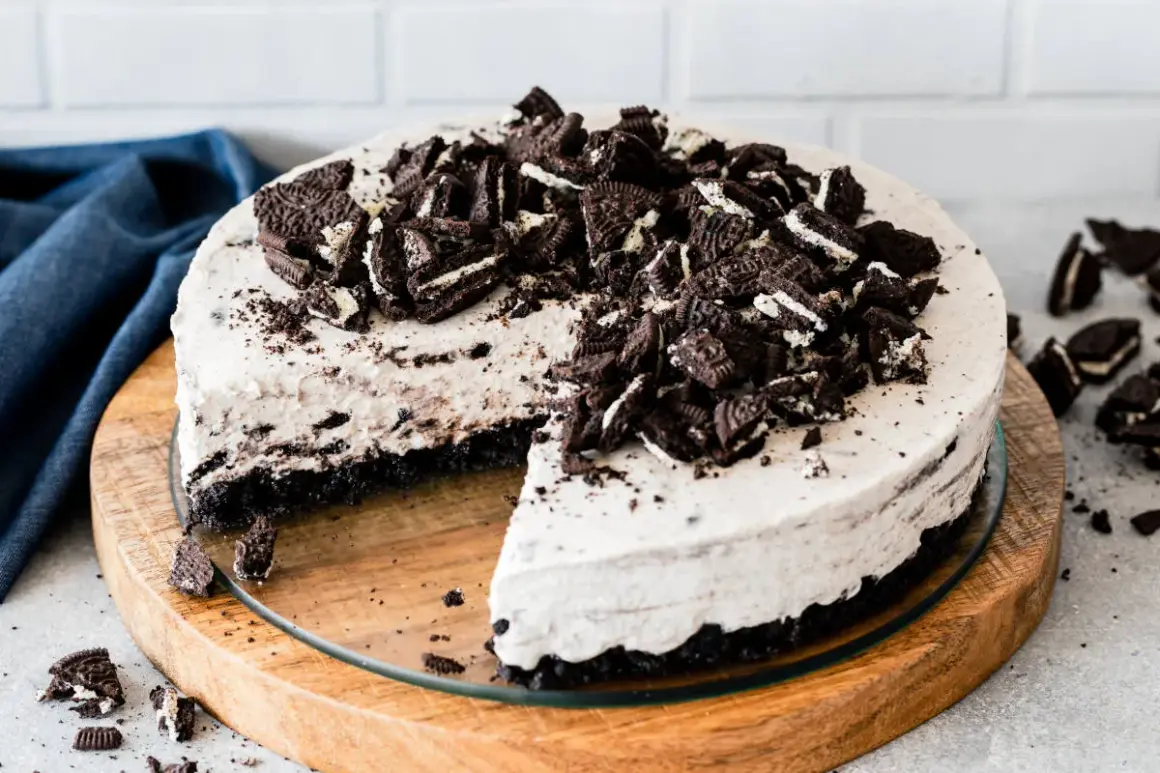 Pyszny sernik oreo na zimno, udekorowany pokruszonymi ciastkami. Idealny deser na gorące dni.