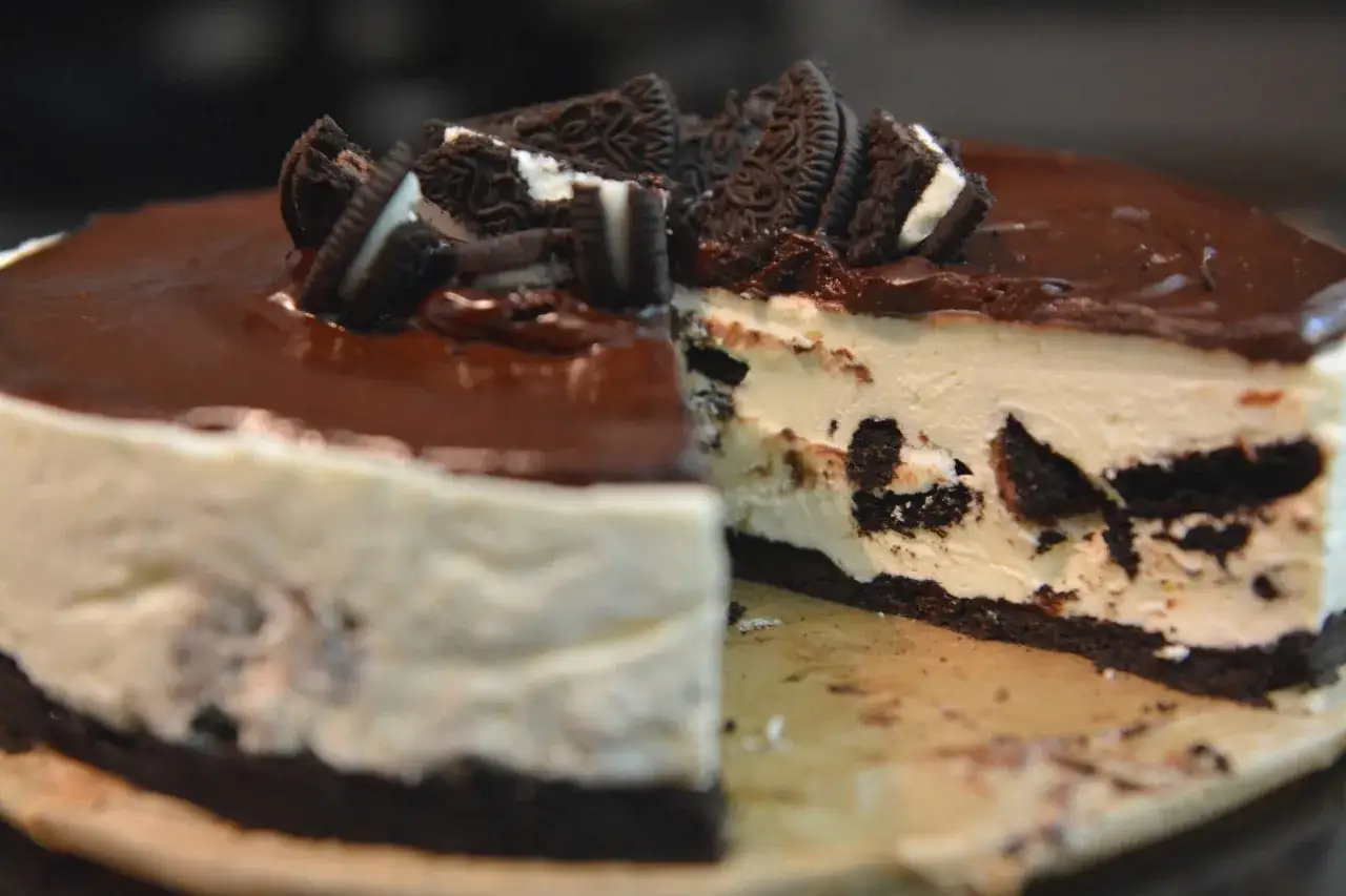 Pyszny sernik oreo na zimno z polewą czekoladową i kawałkami ciastek oreo. Idealny deser na upalne dni.