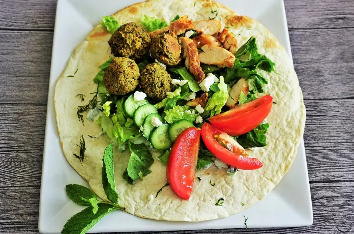 Placki tortilli z falafelami, kurczakiem, sałatą, pomidorami, ogórkiem i fetą. Idealne co do pity na szybki lunch.
