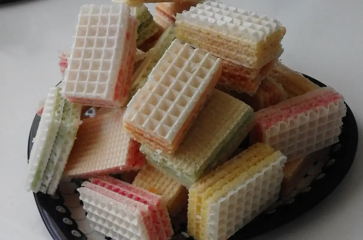 Kolorowe wafle przekładane kremem, idealne na deser. Przepis na wafle z galaretką i śmietaną to świetny pomysł na szybkie słodkości.