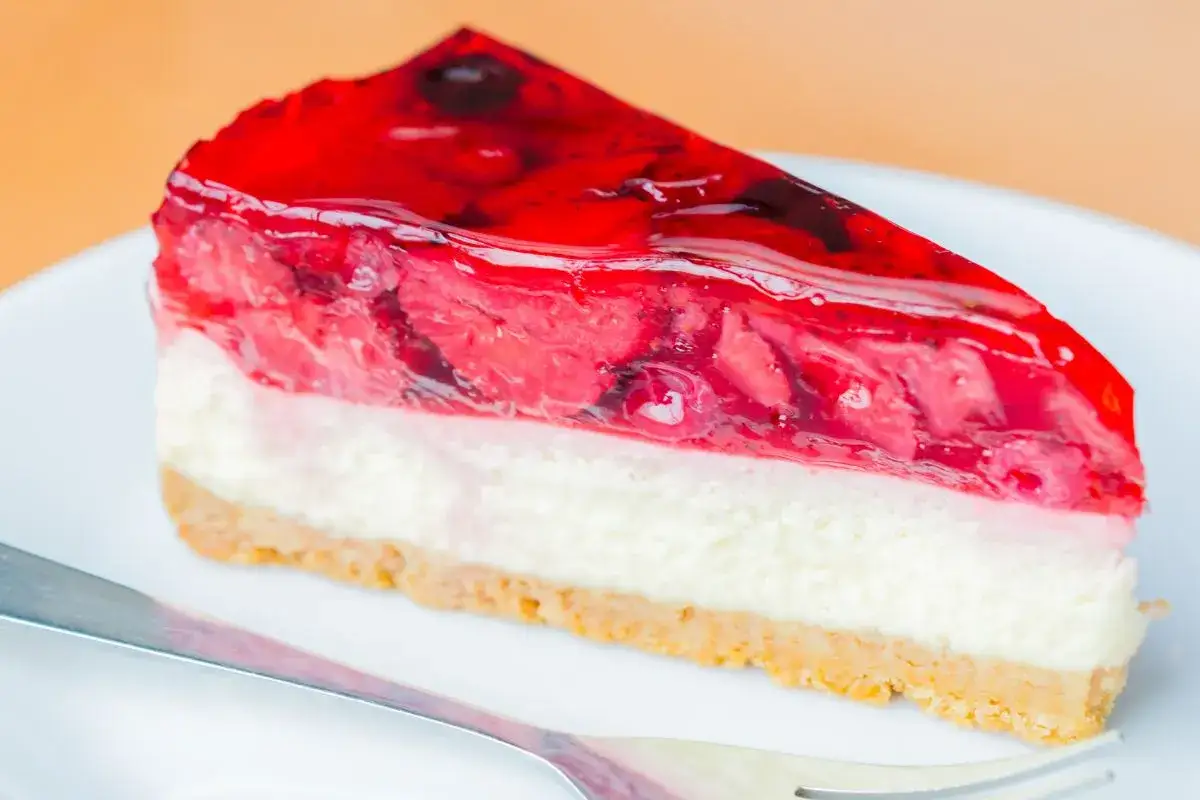 Efektowne ciasto bez pieczenia z warstwą serową, owocami i galaretką. Idealne na deser.