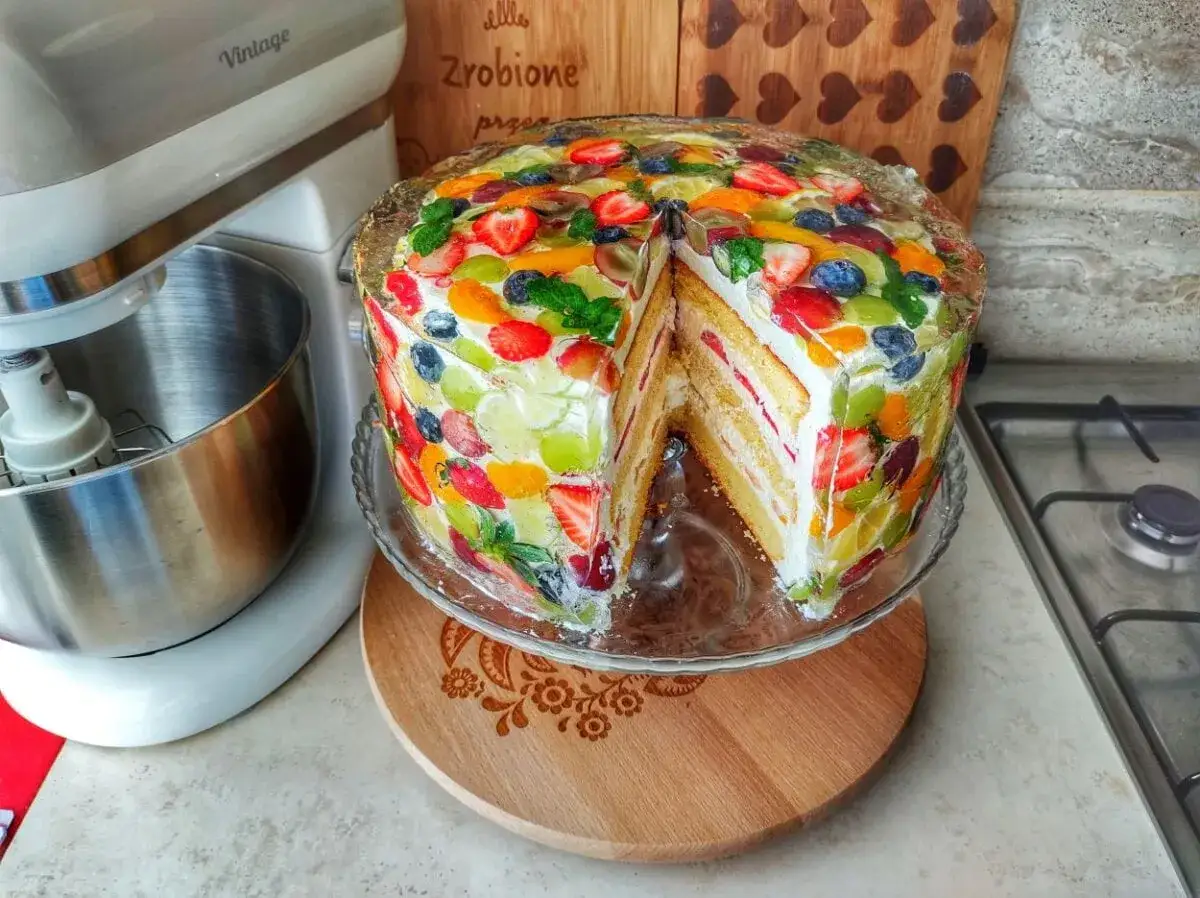 Kolorowy tort z owocami w galaretce, idealny przykład, jak ozdobić tort domowym sposobem. Wygląda pysznie!