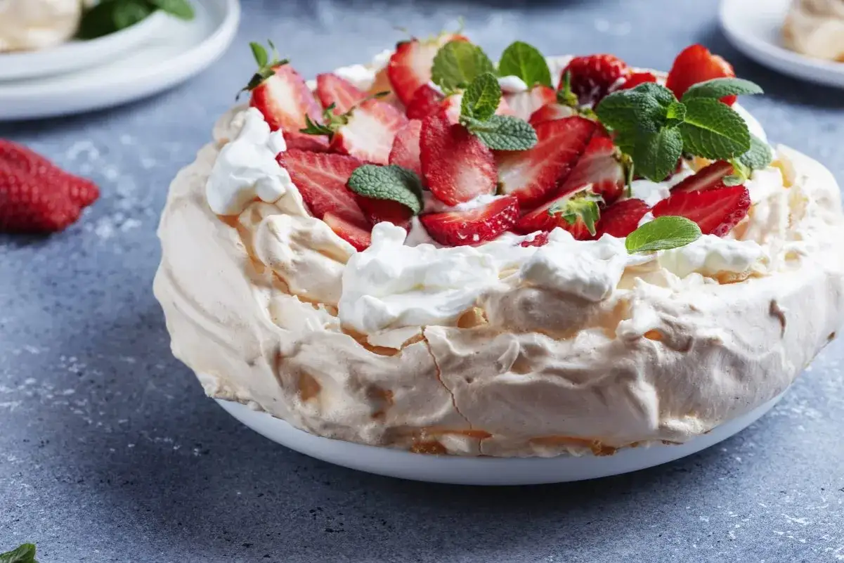 Pyszny tort bezowy z truskawkami i bitą śmietaną. Idealny przepis na letnie popołudnie.