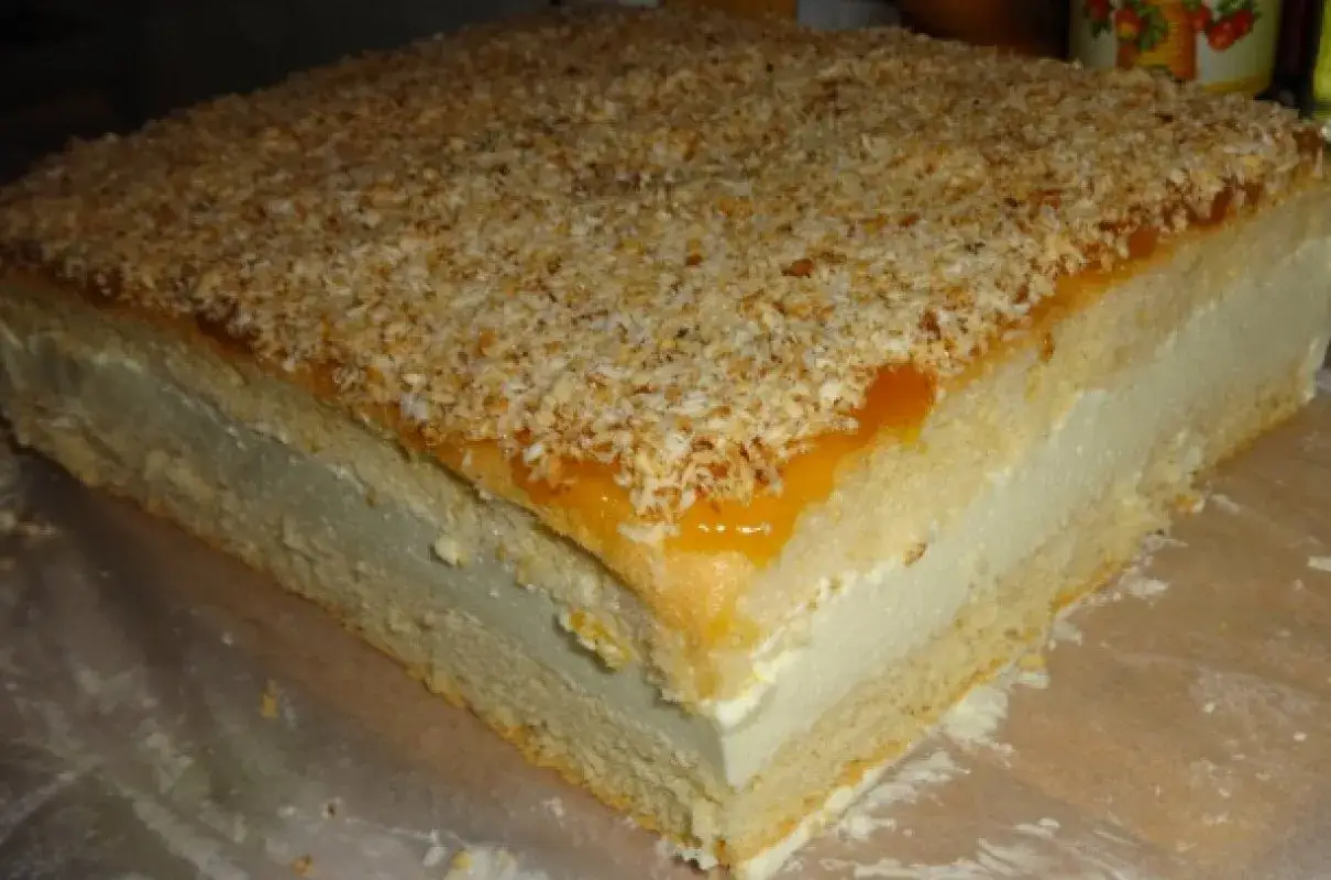 Puszyste ciasto z kremem, polane dżemem i posypane wiórkami kokosowymi. Wygląda jak bogini Wenus na talerzu!