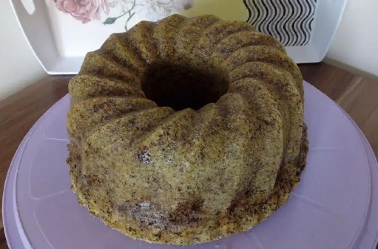 Puszysta babka z orzechami włoskimi, pachnąca domem, czeka na pokrojenie.