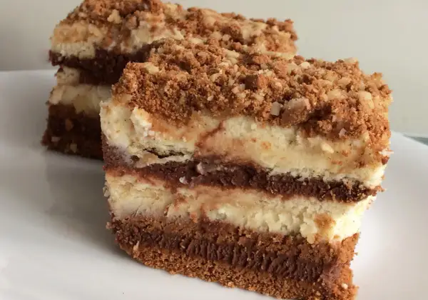 Warstwowe ciasta bez pieczenia z mascarpone, przełożone kremem czekoladowym i posypane kruszonką. Idealne na deser.