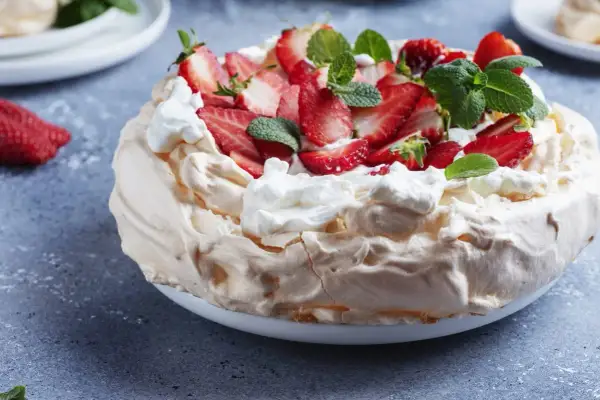 Pyszny tort bezowy z truskawkami i bitą śmietaną. Idealny przepis na letnie popołudnie.