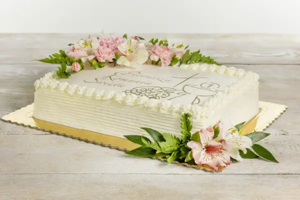 Eleganckie torty na komunie ozdobione kwiatami i symbolem hostii.