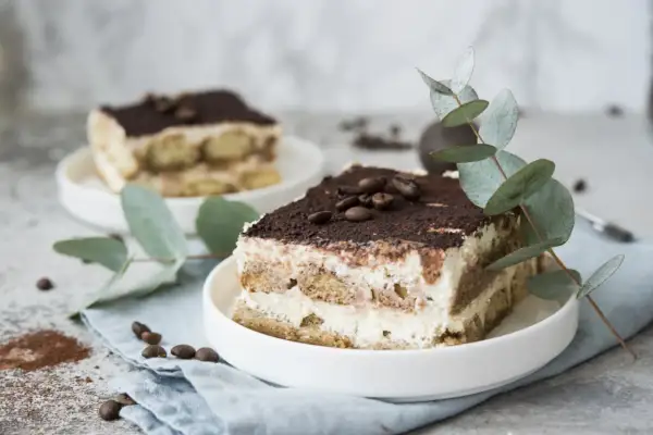 Pyszne tiramisu z serka mascarpone, udekorowane kawą i gałązką eukaliptusa. Idealny deser, gdy zastanawiasz się, co zrobić z serka mascarpone.